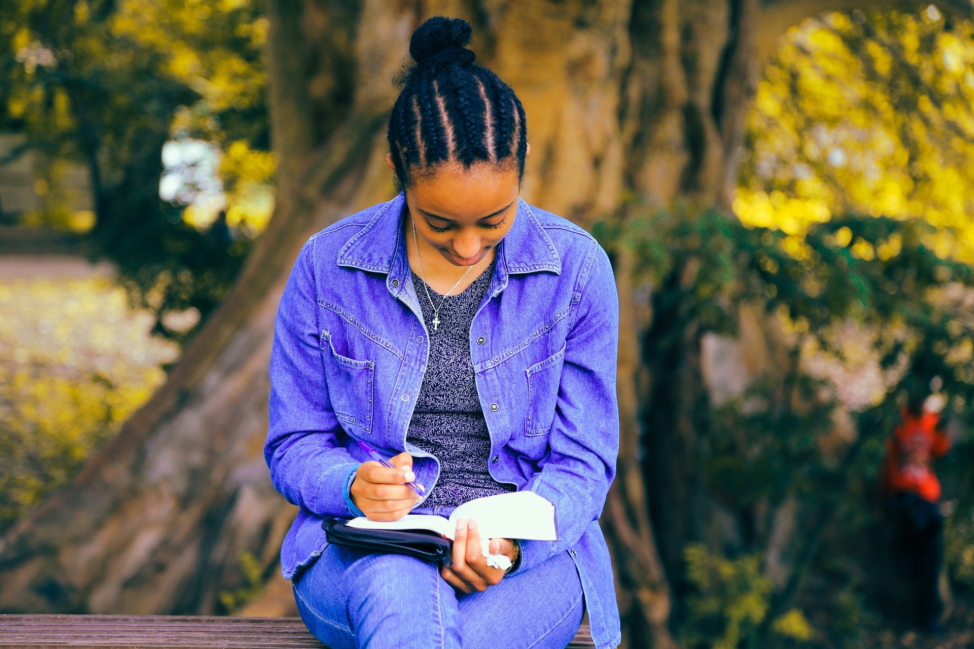 Black woman with natural hairstyle reads book outside