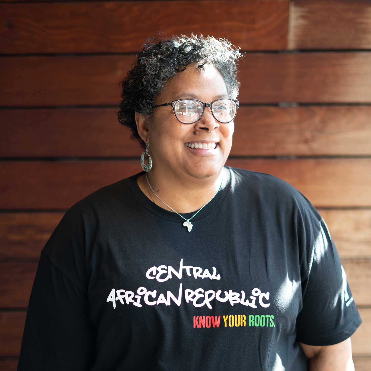  African American Woman wearing a Central African Republic T-Shirt with the words "Know Your Roots" in African Colors