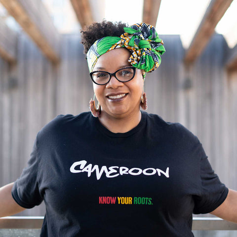 African American Woman wearing a Cameroon T-shirt with "Know Your Roots" written in African Colors